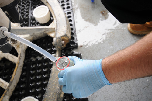 A crewmember on the R/V Ka'imikai-O-Kanaloa fills a sample bottle with water taken from beneath the surface off the northeast coast of Japan in June 2011. The team filled more than 1,500 sample bottles ranging from 50 milliliters to 20 liters that were later shipped to 16 labs in seven countries to be tested for the presence of more than a dozen radioactive isotopes.