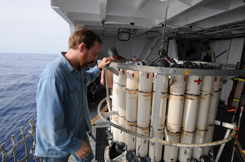 WHOI senior scientist and marine chemist Ken Buesseler (foreground) checks a CTD sampler prior to deploying the instrument to collect data and water samples from the ocean off the coast of Fukushima, Japan.